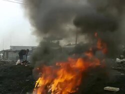 MS Shot of men burning plastic from electric cables to recover copper and others scavenging scrap metal / Lagos, Nigeria Stock Footage