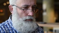 Adult senior bearded man sitting with a laptop Stock Footage