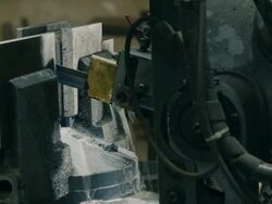 Bandsaw cutting iron beam at factory Stock Footage