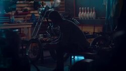 Man sitting in motorcycle workshop drinking coffe Stock Footage