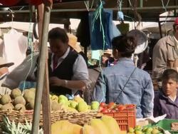 Older gent with cowboy hat walks along thoroughfare past busy market stalls, Villa De Leyva market, Villa De Leyva, BoyacÃƒÂ¡ department, Colombia Stock Footage