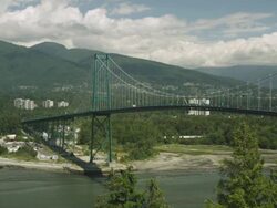 WS Cars driving across suspension bridge with mountains and clouds in distance / Cortes, British Columbia, Canada  Stock Footage
