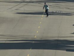 A young man skateboarding in the middle of the street. - Slow Motion Stock Footage
