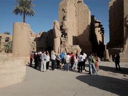 TOURISTS AT COLOSSUS OF RAMSES II IN TEMPLE OF AMUN Stock Footage