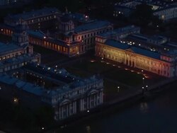Aerial over Greenwich Palace on bank of Thames at night / London Stock Footage