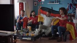 Sport fans sitting on couch watching tv and cheering Stock Footage