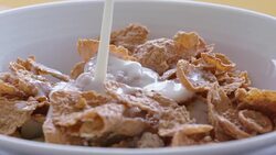 slow motion pouring milk over cereals in a bowl Stock Footage
