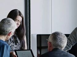 MS PAN businesswoman presenting project on digital tablet to coworkers in high tech startup office Stock Footage