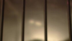 A bare chested man pokes a flaming torch into a cage. Stock Footage