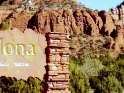 CU PAN Sedona city sign carved in stone to wide view of red rock mountains and Chapel of Holy Cross church / Sedona, Arizona, USA Stock Footage