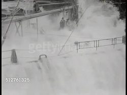 1943: PACIFIC THEATER: REFUELING OPERATION: VS Supply ship refueling Battleship in rough seas, ocean waves splashing over deck, fuel lines connecting ship to ship.  World War II, WWII. Instructional Video