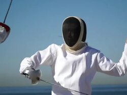 A man and woman fencing on the beach. - Slow Motion Stock Footage