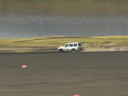 WS AERIAL ZI ZO TS View of cars moving on dusty lava field / Iceland Stock Footage