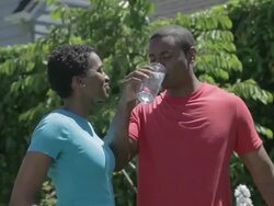  WS Man rking in garden woman emerges from house and hands him beverage / Portland, Oregon, United States  Stock Footage