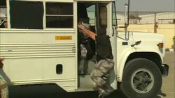 Armed soldiers surround a white bus and apprehend a dissident. Stock Footage