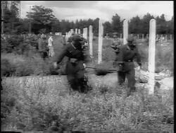 B/W 1961 PAN from soldiers unrolling barbed wire for Berlin Wall to crowd watching / Germany Stock Footage
