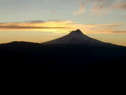 Mount Hood silhouetted against golden sunset and clouds Stock Footage