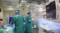 Two doctors and nurse work in operating room Stock Footage