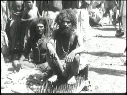 A holy man in India sits on a bed of nails. News Clip