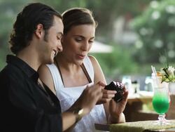young couple on vacation looking at photos on a digital camera Stock Footage
