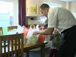 Family putting away food shopping in kitchen News Clip