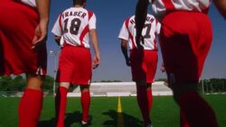 A group of soccer players walk together along the lines of a soccer field. Stock Footage