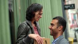 Trendy young man surprises girlfriend with gift-bag outside green Soho storefront Stock Footage