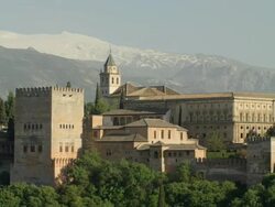LS PAN The Alhambra of Granada with the Sierra Nevada mountain range in background; pan starts approximately at the Torre de Comares, then passes the palace of Charles V, ending at the Alcazaba Stock Footage