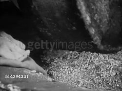 1950: BEAULIEU: DORDOGNE VALLEY:  VS Workers operating old millstone grinder in nut mill, millstone wheel crushing walnut (walnut oil), males pressing nuts to extra nut oil, paste, in container. France, country, nut-mill Instructional Video