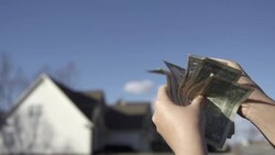 Slow Motion of Counting US Dollar Money in Front of Blurred Homes Stock Footage