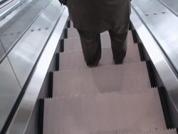  POV Riding down escalator as businessman walks off and shaking hands with associate at bottom / Seattle, Washington, United States Stock Footage