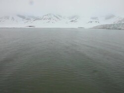 Fog over the Esmark glacier and the mountains nearby covered by snow in the Bay of Ymer,  Spitsbergen, Svalbard archipelago Stock Footage