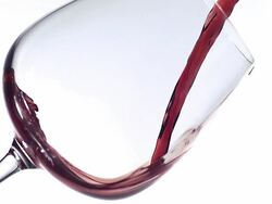 Red wine being poured into glass against white background, slow motion Stock Footage