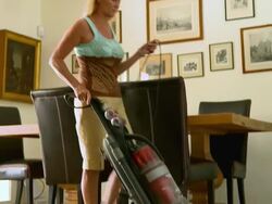 MS  TU TD PAN woman cleaning living room carpet and rugs with upright vacuum cleaner / Rancho Mirage, California, United States Stock Footage