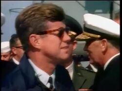 1960s close up PROFILE John Kennedy in sunglasses on ship with naval officers in background / newsreel Stock Footage