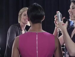 MS TU Stylists making final adjustments on female model backstage at fashion show Stock Footage