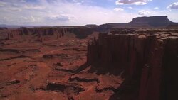 Flying over cliff edge to reveal canyon at Cannyonlands National Park Utah Stock Footage