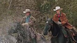 SLO MO Male and female ranger crossing river on horses Stock Footage