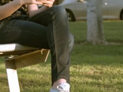 MCU PAN teenage girl texting while sitting on park bench holding smart phone in her hand   / Redlands, California, USA Stock Footage