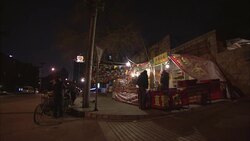 A father and child shop for fireworks at an outdoor market at night. Stock Footage