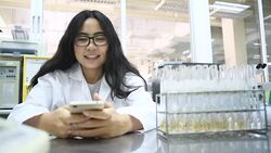 Young Asian women scientist play phone game in laboratory Stock Footage