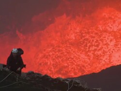 Gas blows past climber standing above lava lake, Marum Volcano, Ambrym Island, Vanuatu Stock Footage