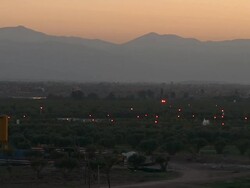 WS View of mountains with cars driving by very far away around dusk / Marrakech, Tensift, Morocco  Stock Footage