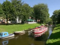 WS View of people enjoying ferry ride passing from canal, North Sea North Frisia / Friedrichstadt, Schleswig Holstein, Germany Stock Footage