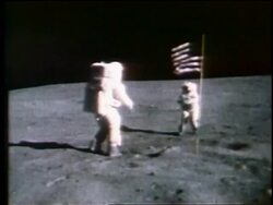 1972 astronaut turning + saluting by American flag as other astronaut takes photograph on Moon Stock Footage