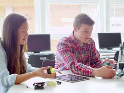 MS two high school students working together on robotics project on digital tablet at table in classroom Stock Footage