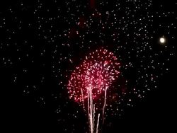 WS View of Fireworks shooting up from ground and exploding in night sky with full moon / Wantagh, New York, United States Stock Footage