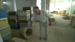 An archaeologist walks through a warehouse looking at artifacts. Stock Footage