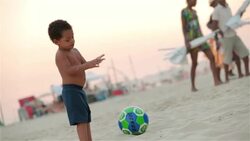 Young Brazilian boy brushes sand off hands and rubs belly on Copacabana Beach Stock Footage