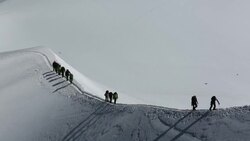 Climbers on the arete leading up from the Vallee Blanche to the Aiguille Du Midi above Chamonix, France Stock Footage